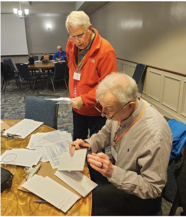Dennis Garcia, chapter vice president of education, and Leigh Armistead calculate the final scores at the March event.